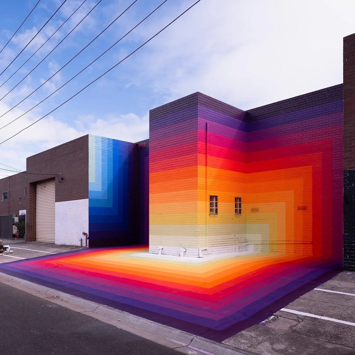 Chromatic Pulse, a rainbow gradient mural wrapping a warehouse building