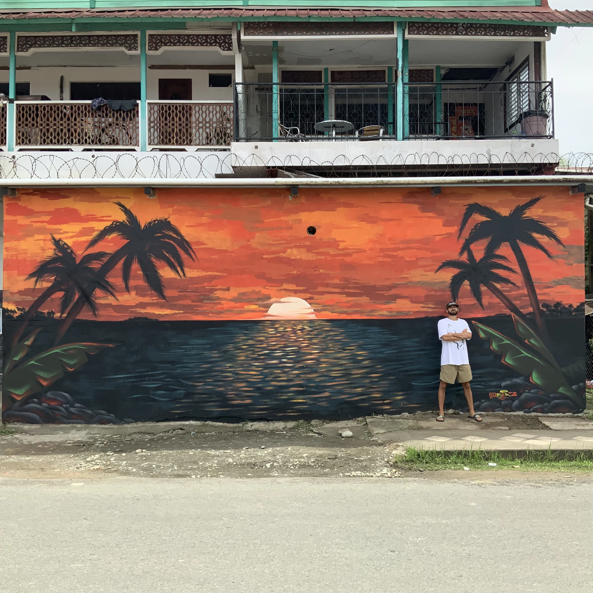 Sunset and palm tree mural painted on a building wall in Bocas del Toro, Panama