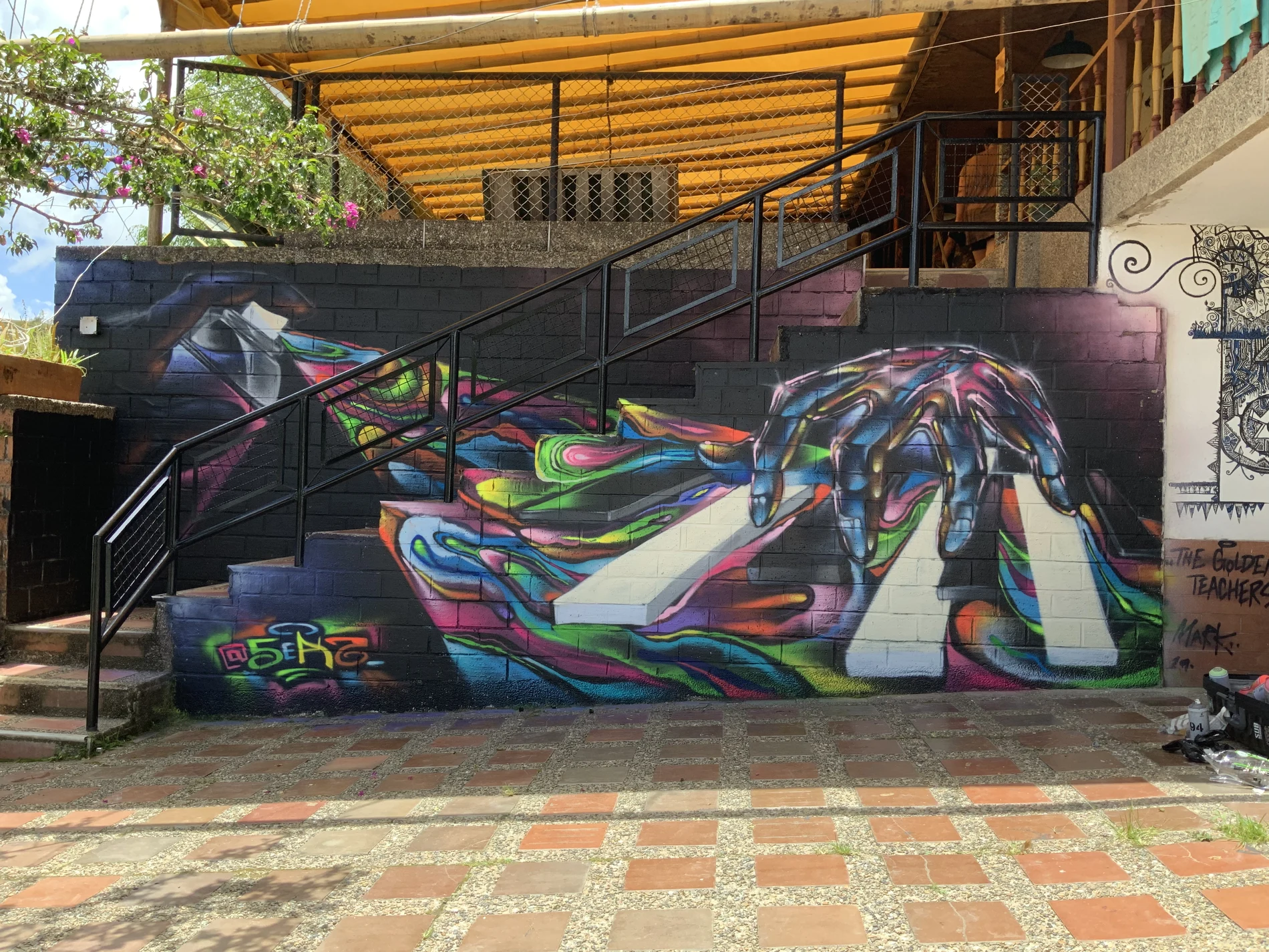 Colourful hand and piano keys mural painted across a staircase in Guatapé, Colombia